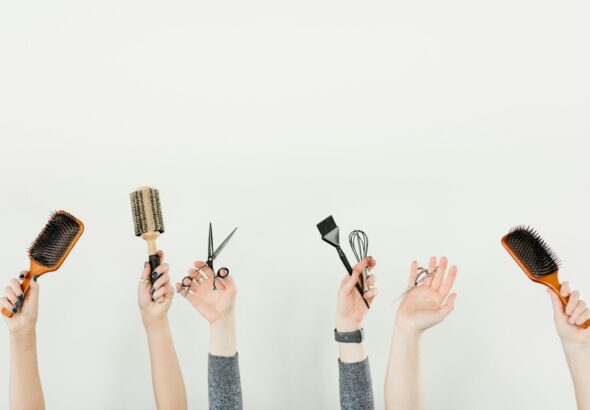 person holding silver and black hair brush